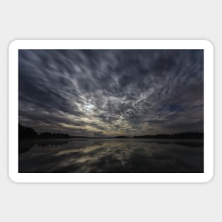 Dynamic clouds in the night over the lake lit by full moon Sticker